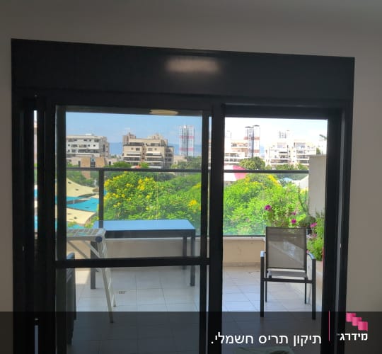 מרפסת עם שולחן וכיסאות, נוף לעיר דרך חלון עם תריסים